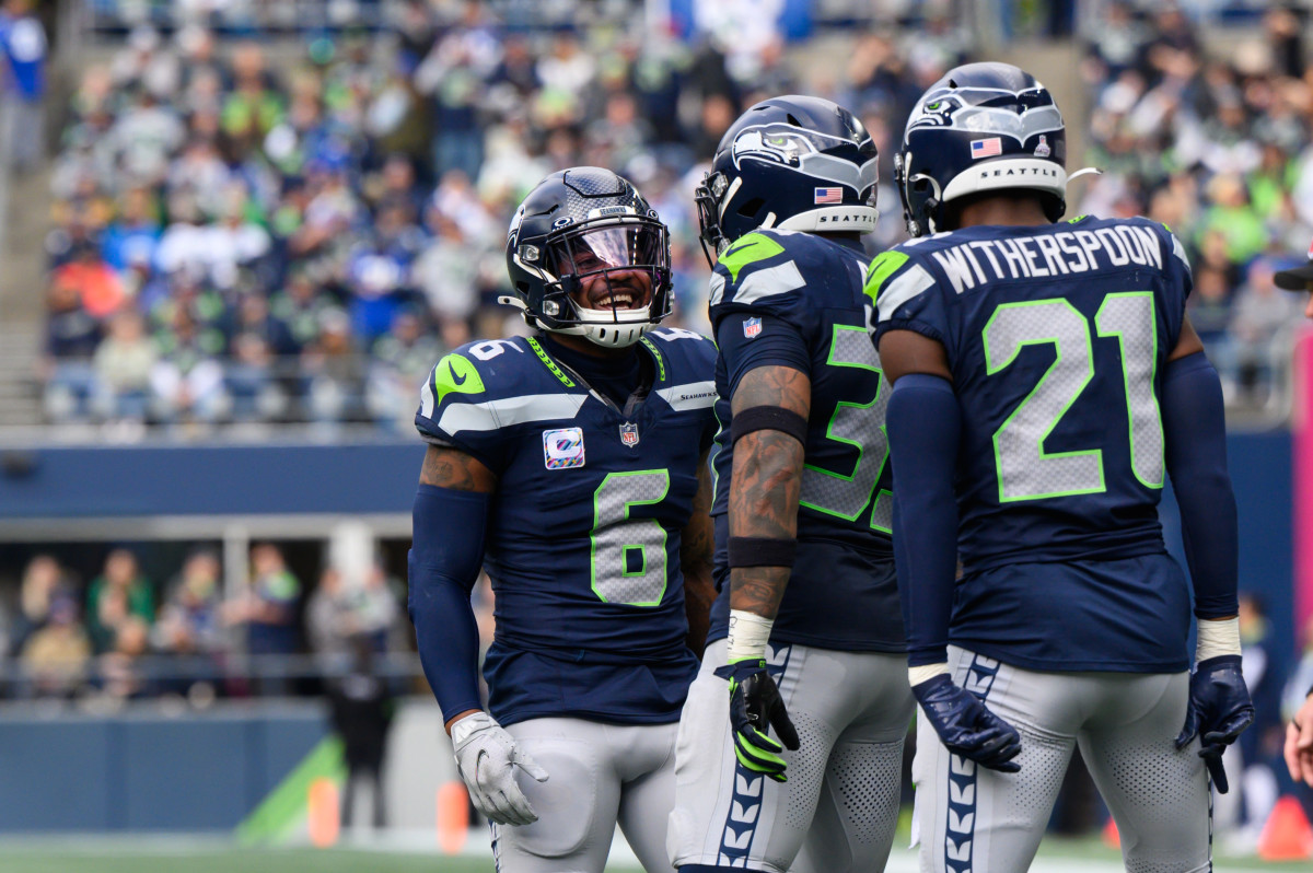 Oct 22, 2023; Seattle, Washington, USA; Seattle Seahawks safety Quandre Diggs (6) and safety Jamal Adams (33) and cornerback Devon Witherspoon (21) celebrate after the defense made a play against the Arizona Cardinals during the second half at Lumen Field. Mandatory Credit: Steven Bisig-USA TODAY Sports