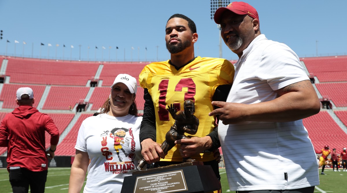 USC Trojans quarterback Caleb Williams (13) holds the Heisman Trophy with his parents during the Spring Game.