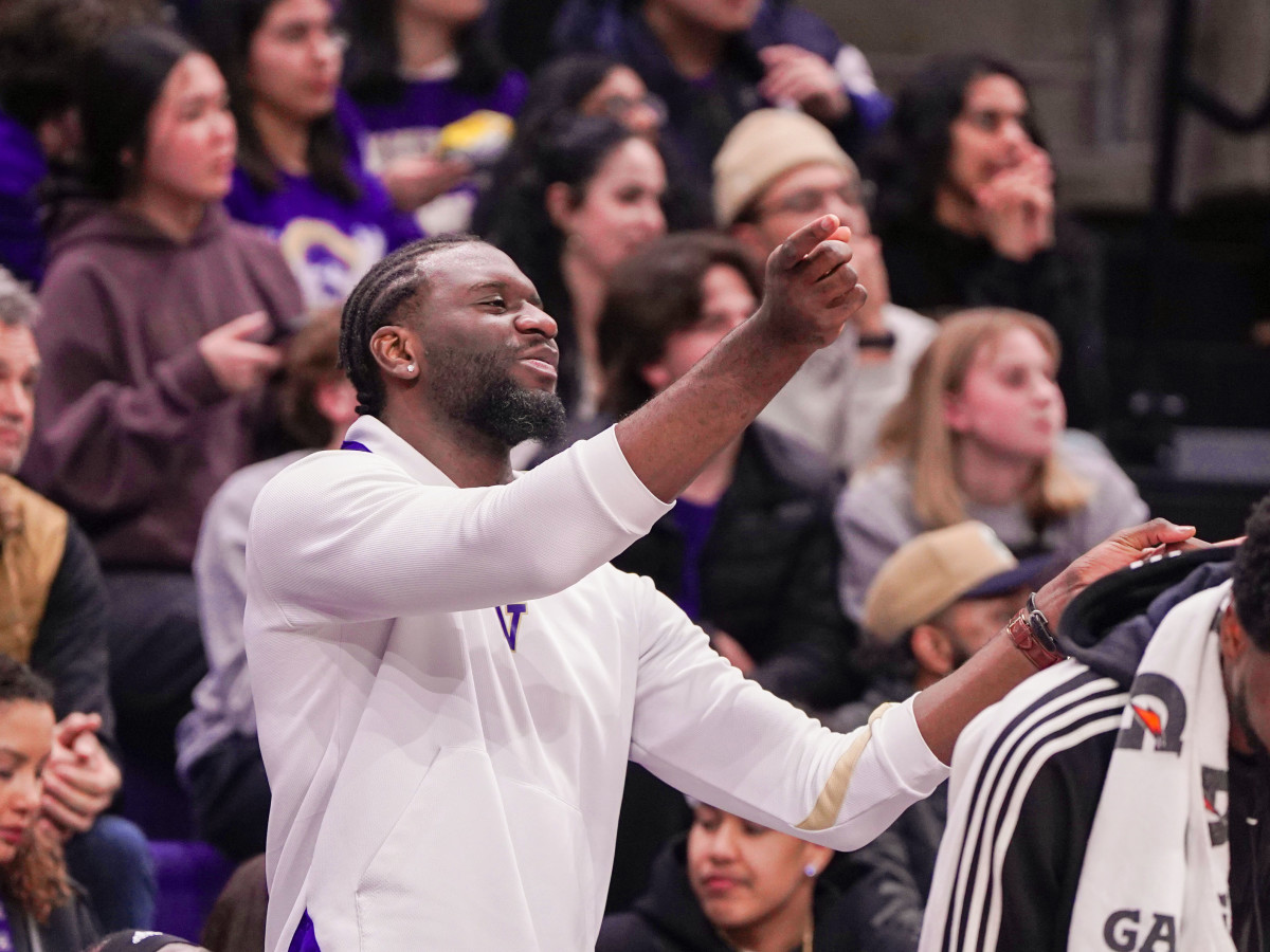 Franck Kepnang cheers on the Huskies against UCLA from the UW bench.