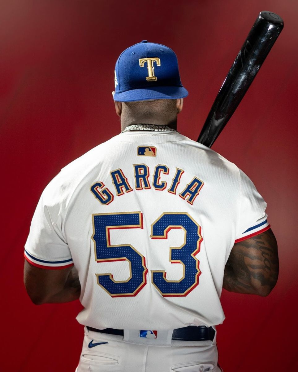 Texas Rangers right-fielder Adolis Garcia poses in the club's World Series championship-inspired gold-trimmed jerseys and caps, which they'll wear against the Chicago Cubs on Opening Day on March 28 at Globe Life Field. The jerseys and caps will be available for purchase at the ballpark on March 21.