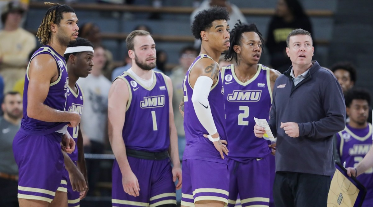 James Madison Dukes head coach Mark Byington, right, and his players watch a replay during the second against the Southern Miss Golden Eagles half at Reed Green Coliseum in Hattiesburg, Mississippi, on Jan. 6, 2024.
