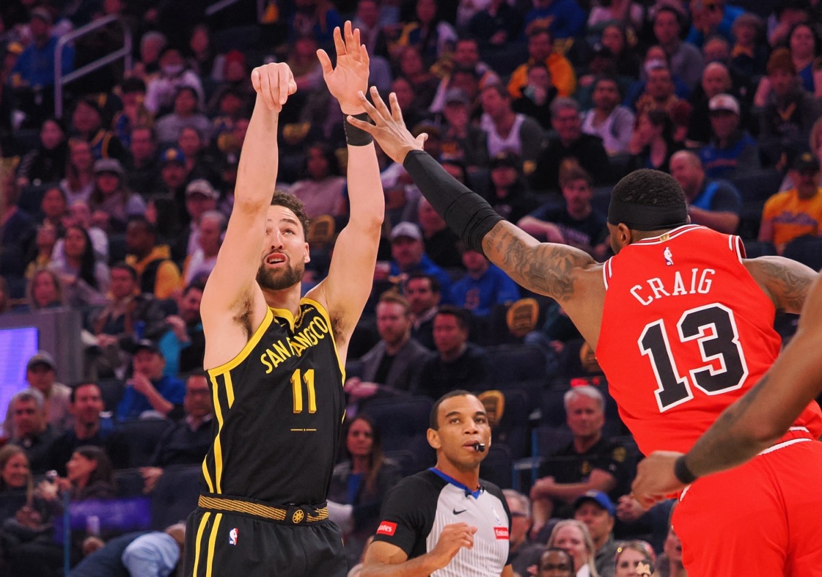 Golden State Warriors guard Klay Thompson (11) scores a three-point basket against the Chicago Bulls forward Torrey Craig (13) during the first quarter at Chase Center.