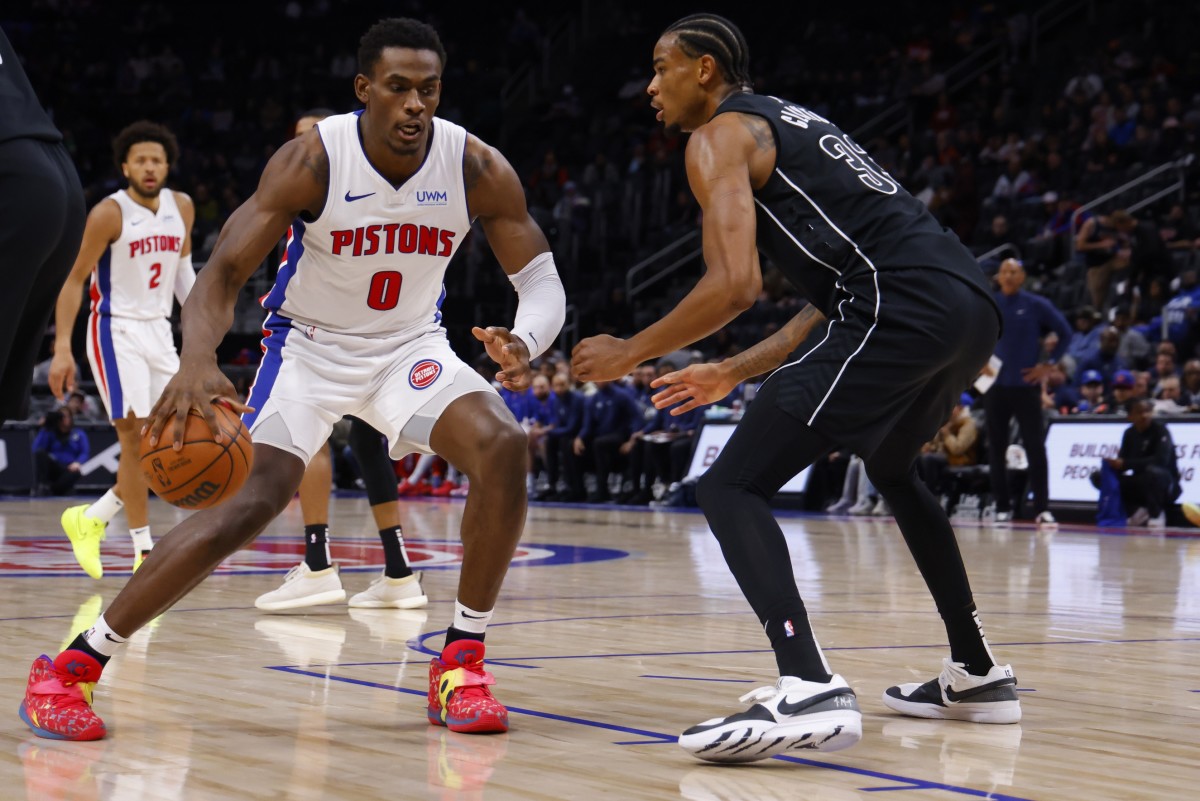 Detroit Pistons center Jalen Duren (0) dribbles defended by Brooklyn Nets center Nic Claxton (33) in the first half at Little Caesars Arena.