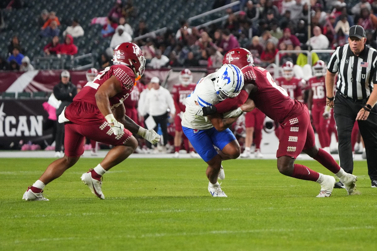 Oct 20, 2023; Philadelphia, Pennsylvania, USA; Temple Owls linebacker Jacob Hollins (12) and Temple Owls linebacker Jordan Magee (6) tackle SMU Mustangs wide receiver Jake Bailey (12) during the first half at Lincoln Financial Field. Mandatory Credit: Gregory Fisher-USA TODAY Sports  