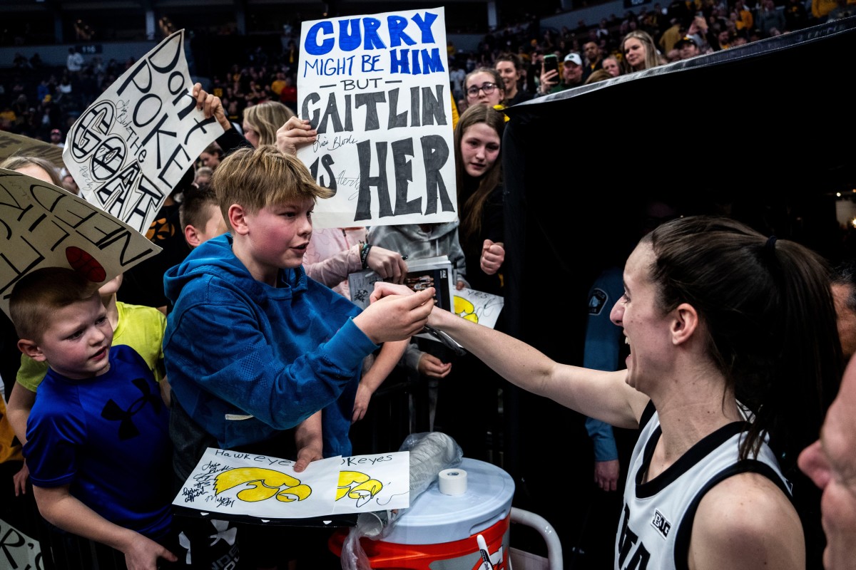 Iowa guard Caitlin Clark (22) gives a fan her headband during the Big Ten Women's Basketball tournament quarterfinals at the Target Center on Friday, March 8, 2024, in Minneapolis, Minn.