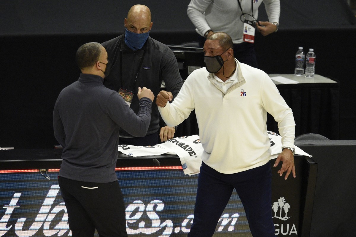 Philadelphia 76ers head coach Doc Rivers (right) meets with LA Clippers head coach Tyronn Lue