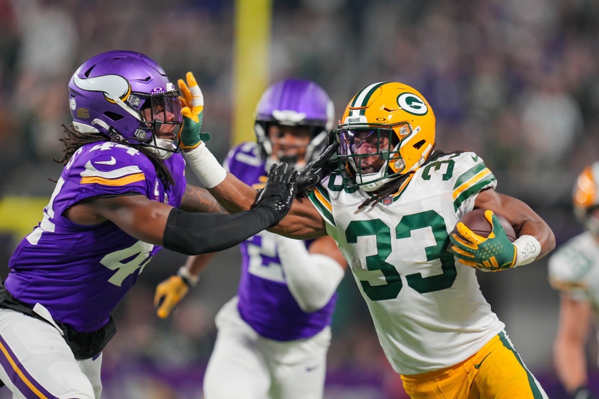 Dec 31, 2023; Minneapolis, Minnesota, USA; Green Bay Packers running back Aaron Jones (33) runs with the ball against the Minnesota Vikings safety Josh Metellus (44) in the first quarter at U.S. Bank Stadium.