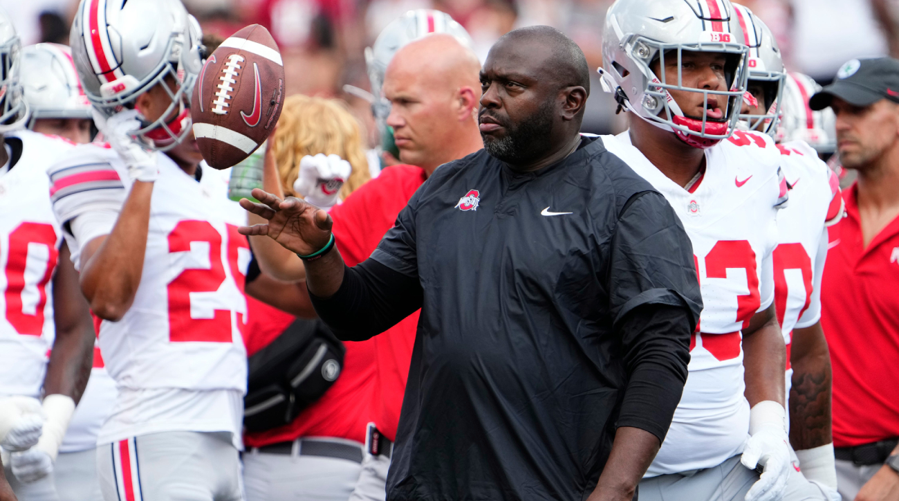 Ohio State running backs coach Tony Alford flips a ball during a game.
