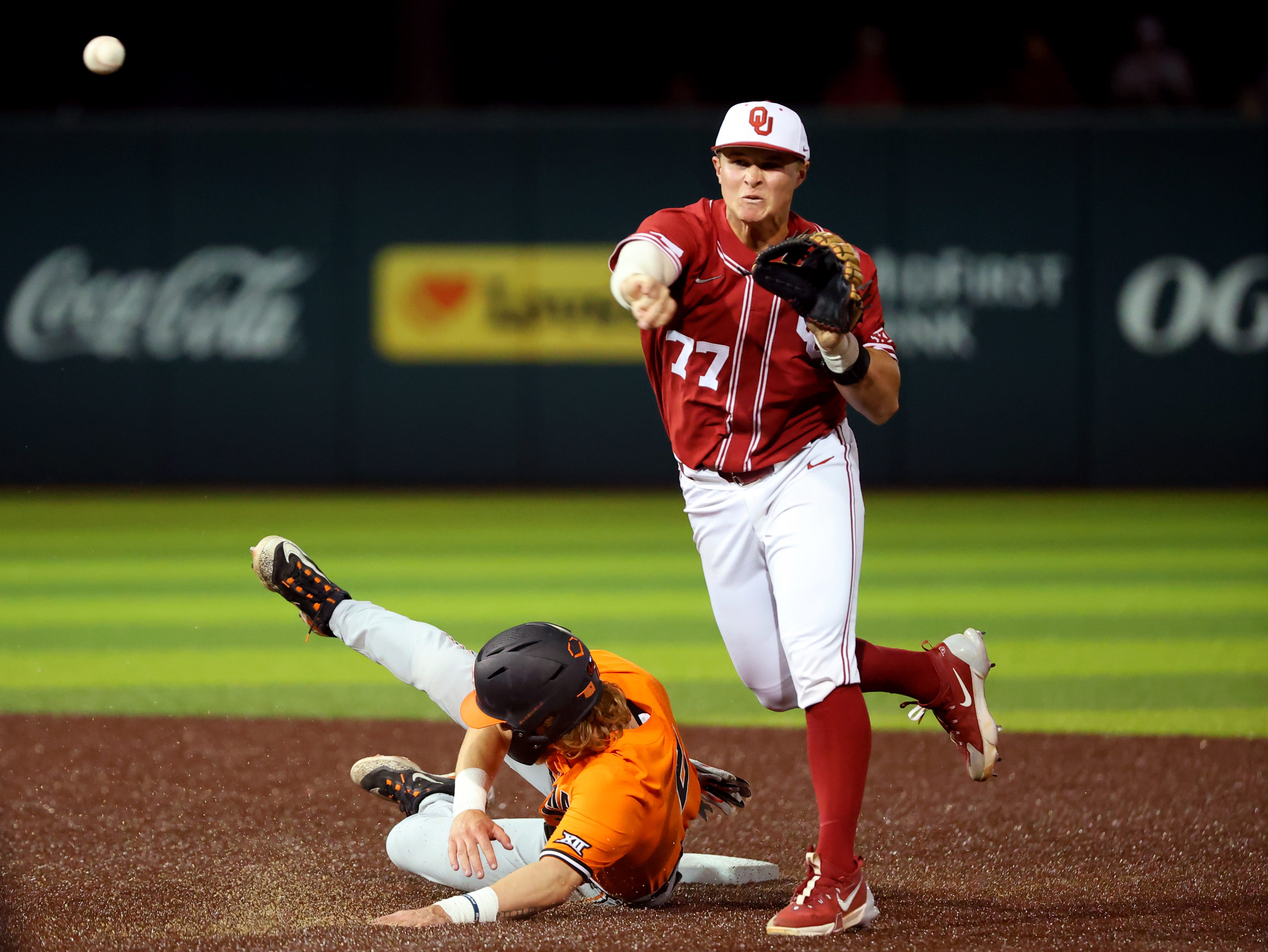 Oklahoma's Jaxon Willits (77) turns a double as Oklahoma State's Aidan Meola (2) slides into second during the college Bedlam baseball game between the University of Oklahoma Sooners and Oklahoma State University Cowboys in Norman, Okla., Tuesday, March 12, 2024.