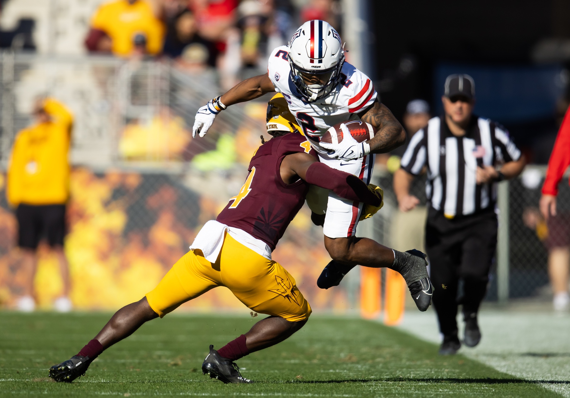 Nov 25, 2023; Tempe, Arizona, USA; Arizona Wildcats running back Jacob Cowing (2) is tackled by Arizona State Sun Devils defensive back Demetries Ford (4) in the first half of the Territorial Cup at Mountain America Stadium. Mandatory Credit: Mark J. Rebilas-USA TODAY Sports  