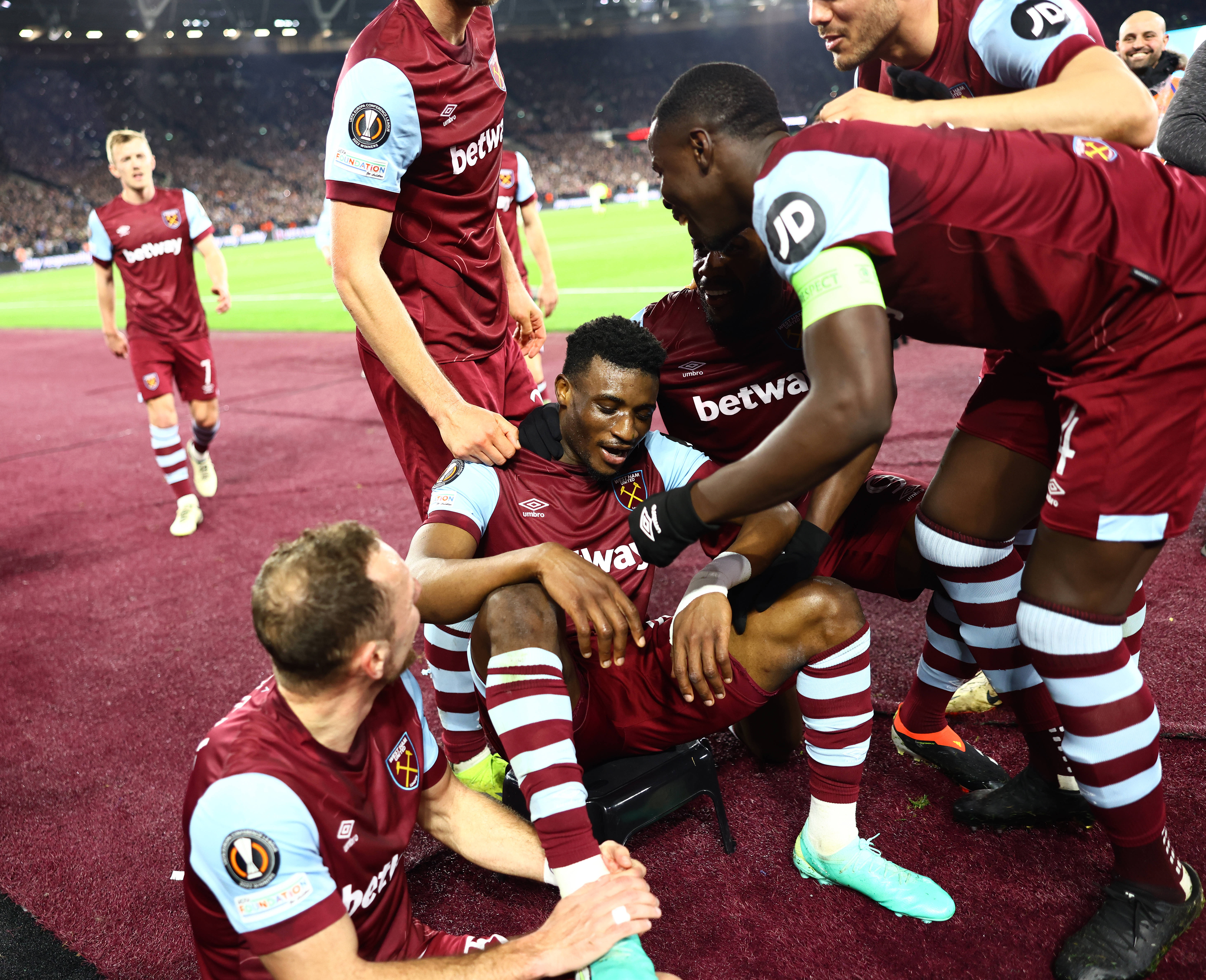 Mohammed Kudus pictured (center) sitting on a plastic stool while being mobbed by his teammates after scoring an amazing solo goal for West Ham United in a 5-0 win over Freiburg in the UEFA Europa League in March 2024