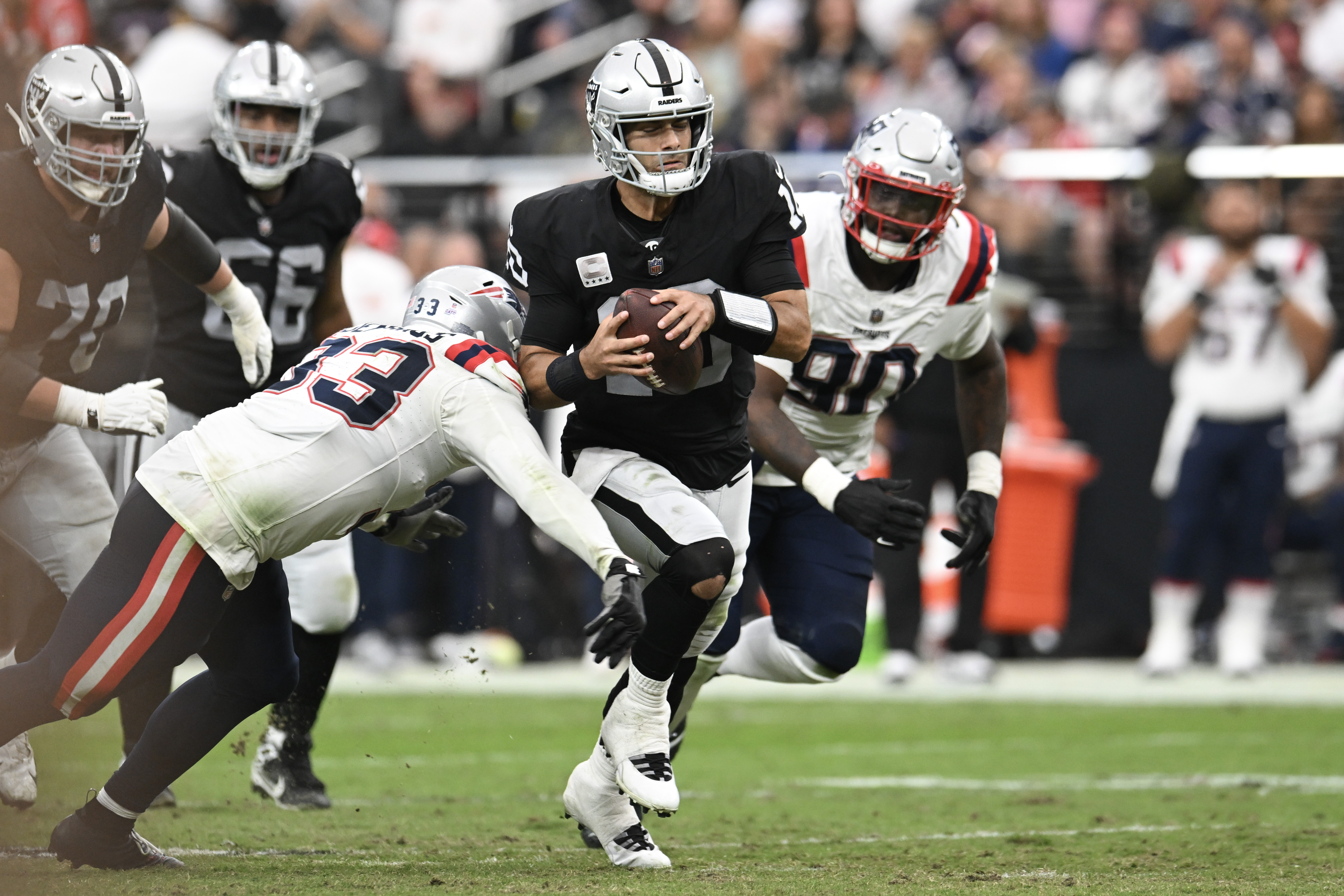 Oct 15, 2023; Paradise, Nevada, USA; Las Vegas Raiders quarterback Jimmy Garoppolo (10) is tackled by New England Patriots linebacker Anfernee Jennings (33) in the second quarter at Allegiant Stadium. 