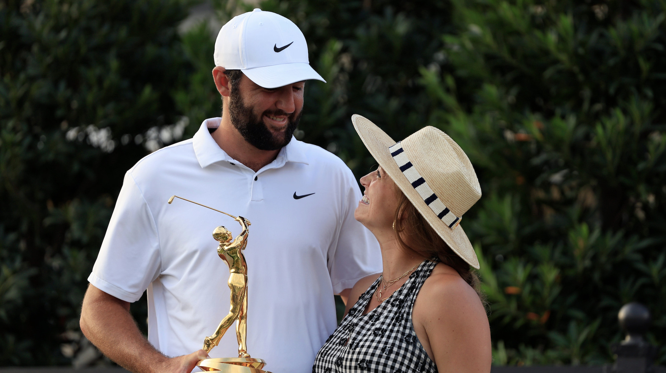 Scottie Scheffler looks to his wife Meredith Scudder as he poses for photos with the championship trophy after the fourth and final round of The Players Championship PGA golf tournament Sunday, March 17, 2024 at TPC Sawgrass in Ponte Vedra Beach, Fla. Scheffler won at 20 under par and is the first defending champion in the 50 year history of the event.