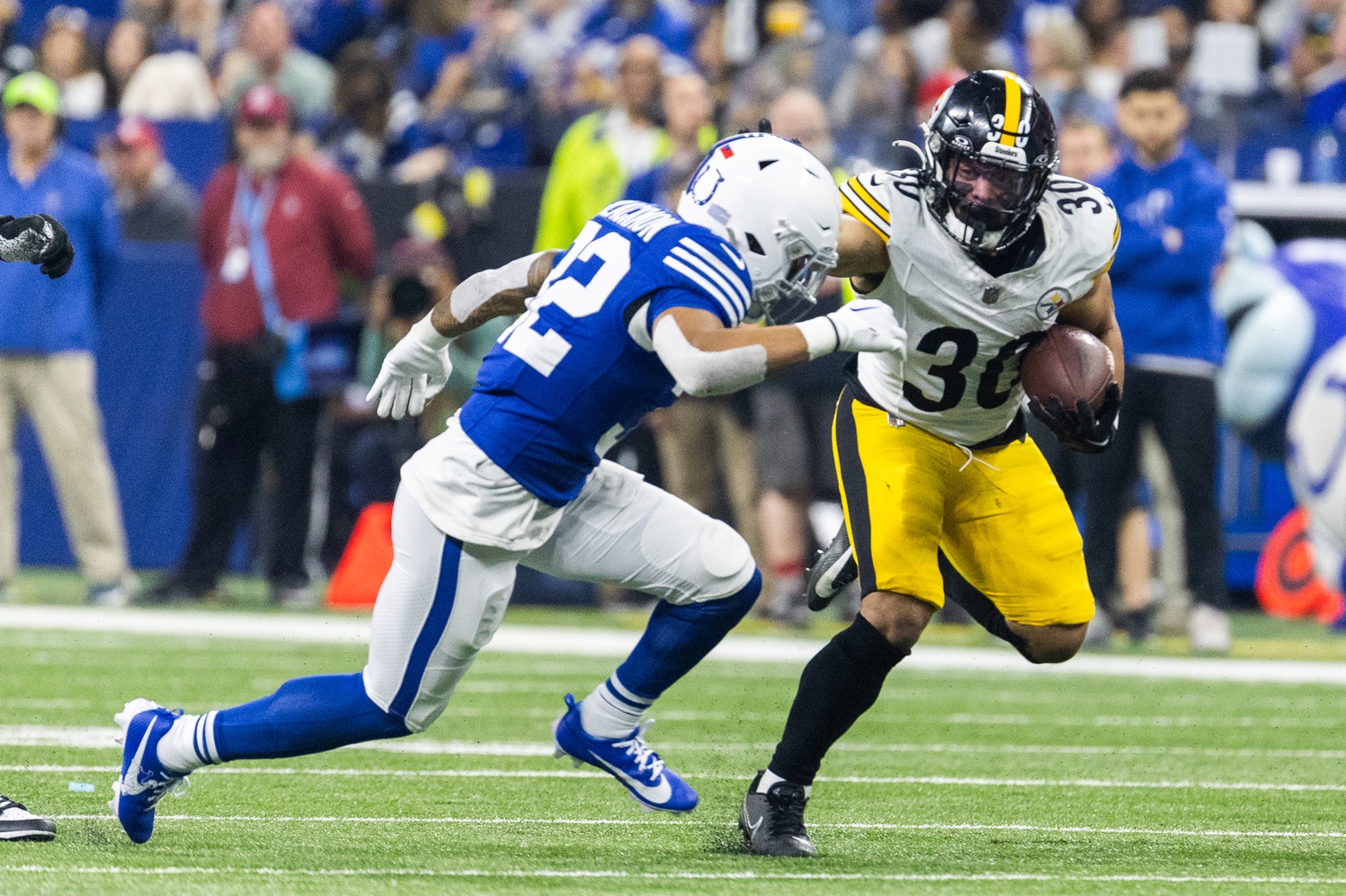 Dec 16, 2023; Indianapolis, Indiana, USA; Pittsburgh Steelers running back Jaylen Warren (30) runs the ball while Indianapolis Colts safety Julian Blackmon (32) defends in the first half at Lucas Oil Stadium.