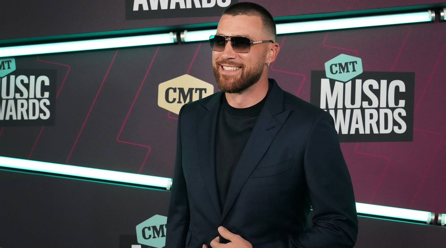 Chiefs tight end Travis Kelce smiles on the red carpet at the CMT Music Awards.