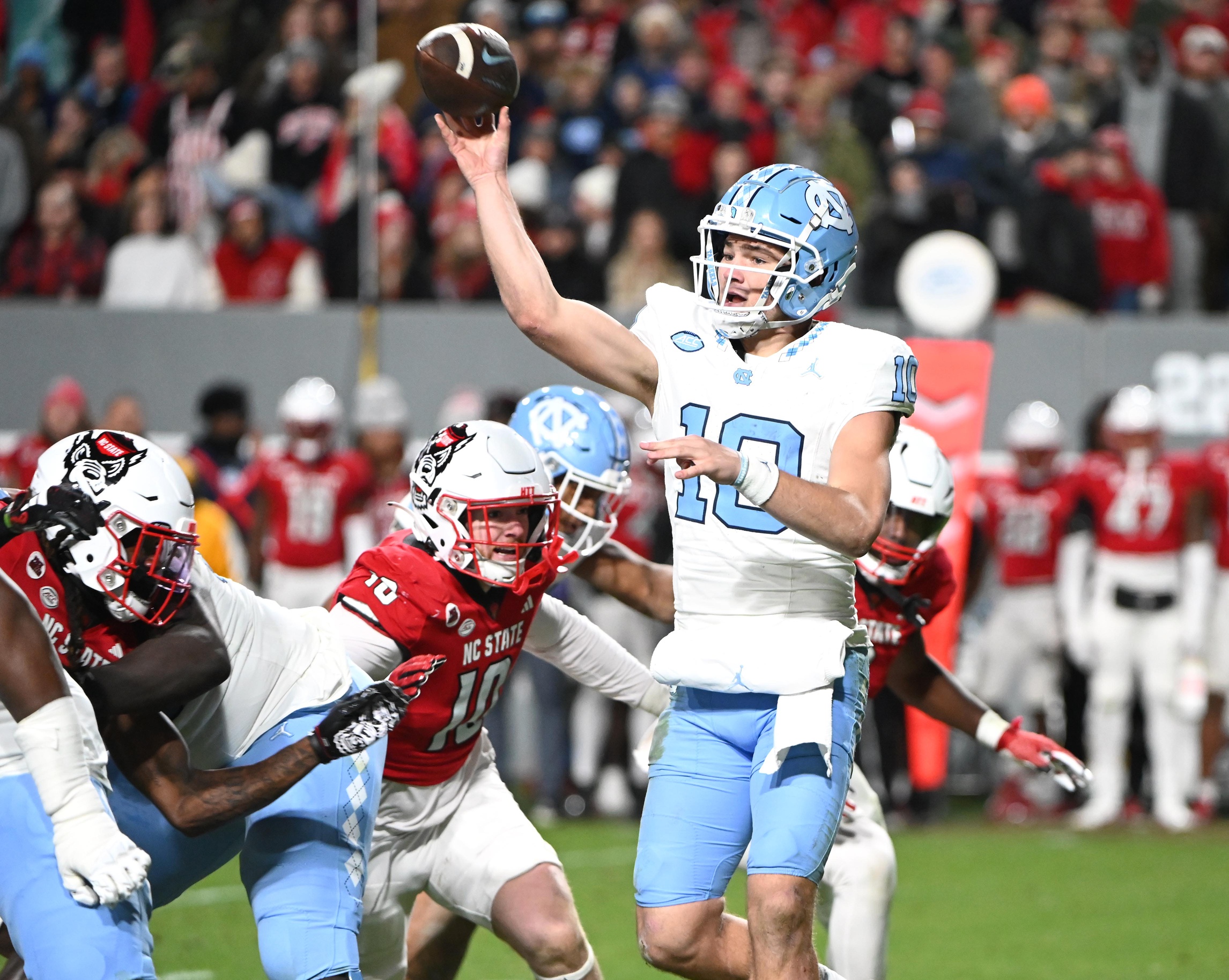 Nov 25, 2023; Raleigh, North Carolina, USA; North Carolina Tar Heels quarterback Drake Maye (10) throws a pass against North Carolina State Wolfpack linebacker Caden Fordham during the first half at Carter-Finley Stadium.