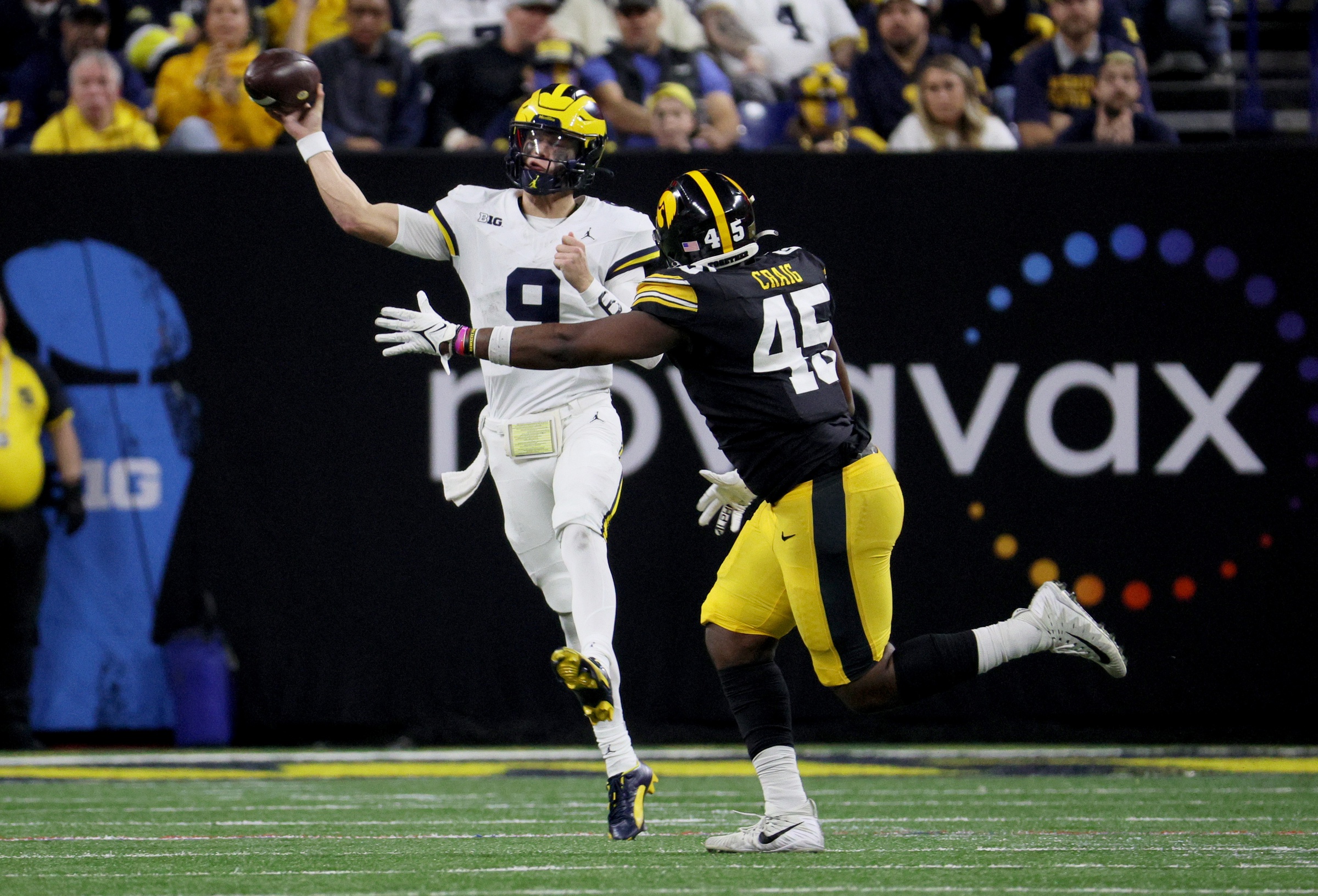 Dec 2, 2023; Indianapolis, IN, USA; Michigan Wolverines quarterback J.J. McCarthy (9) throws in front of Iowa Hawkeyes defensive lineman Deontae Craig (45) during the second half of the Big Ten Championship game at Lucas Oil Stadium.