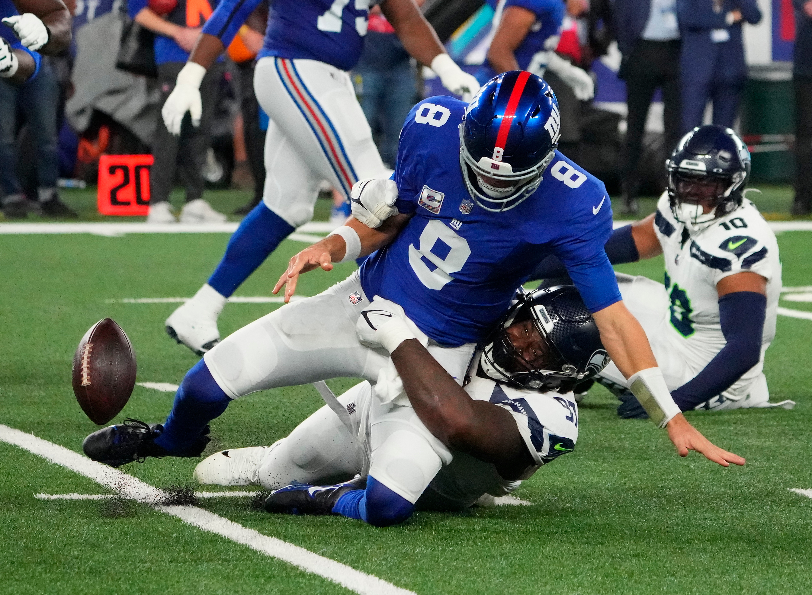Seahawks defensive end Mario Edwards Jr. (97) strips the ball from New York Giants quarterback Daniel Jones (8) and the Seahawks recovered at MetLife Stadium.