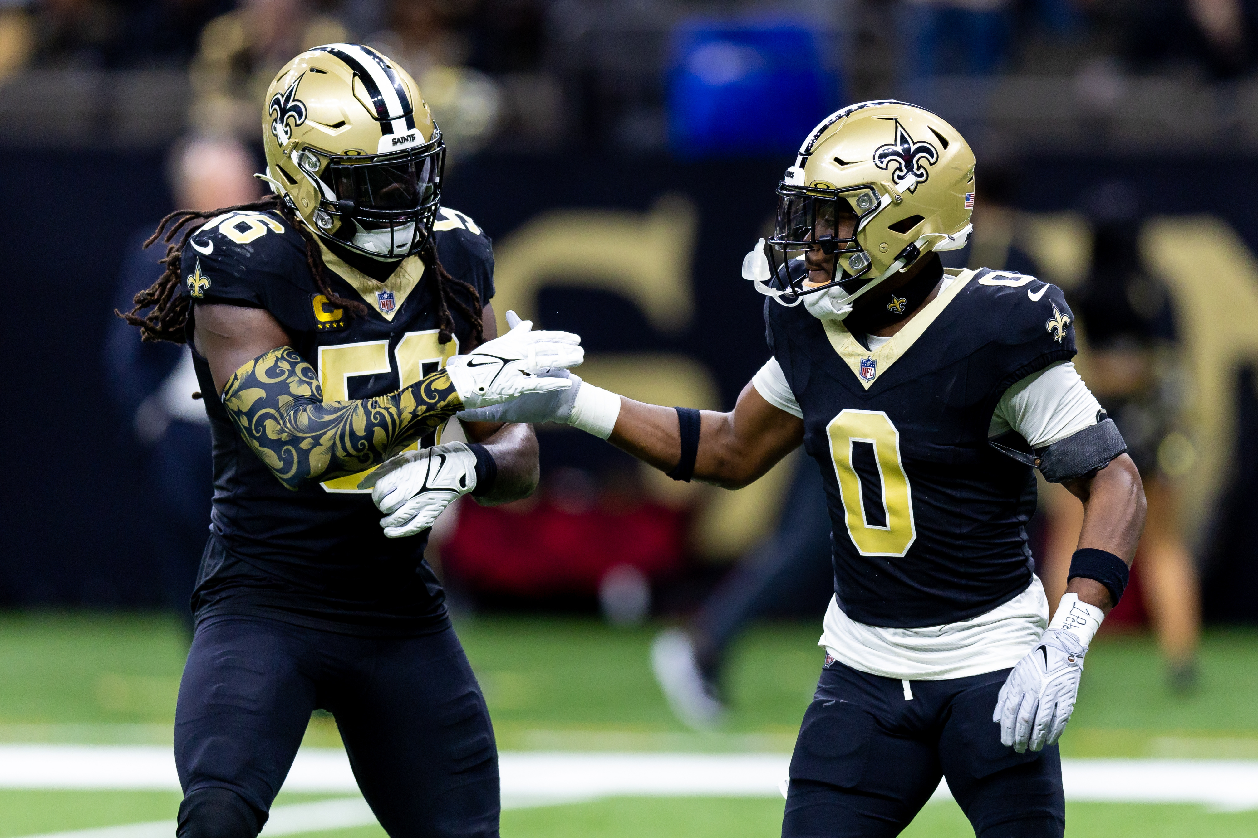 New Orleans Saints linebacker Demario Davis (56) and safety Ugo Amadi (0) celebrate after a play.