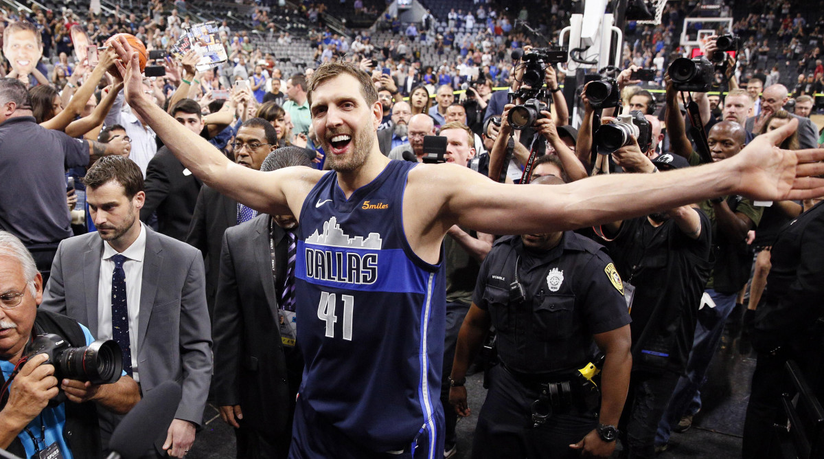 Dallas Mavericks power forward Dirk Nowitzki high fives fans while leaving the court after the game in his final season.
