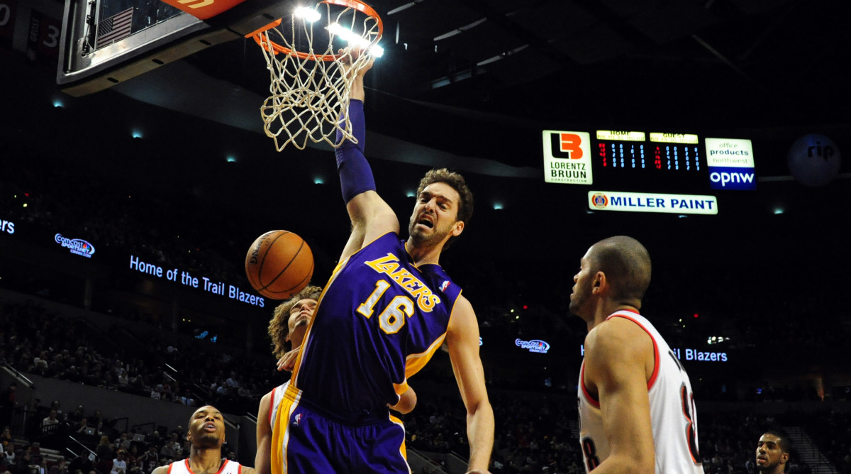 Los Angeles Lakers center Pau Gasol dunks the ball on Portland Trail Blazers center Robin Lopez  and small forward Nicolas Batum in 2014.