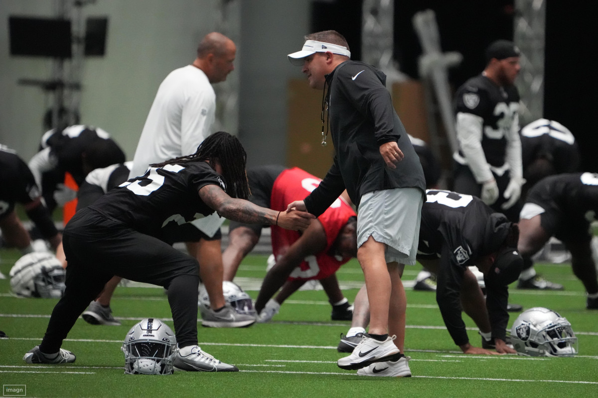 Las Vegas Raiders coach Josh McDaniel shakes hands with safety Tre'von Moehrig