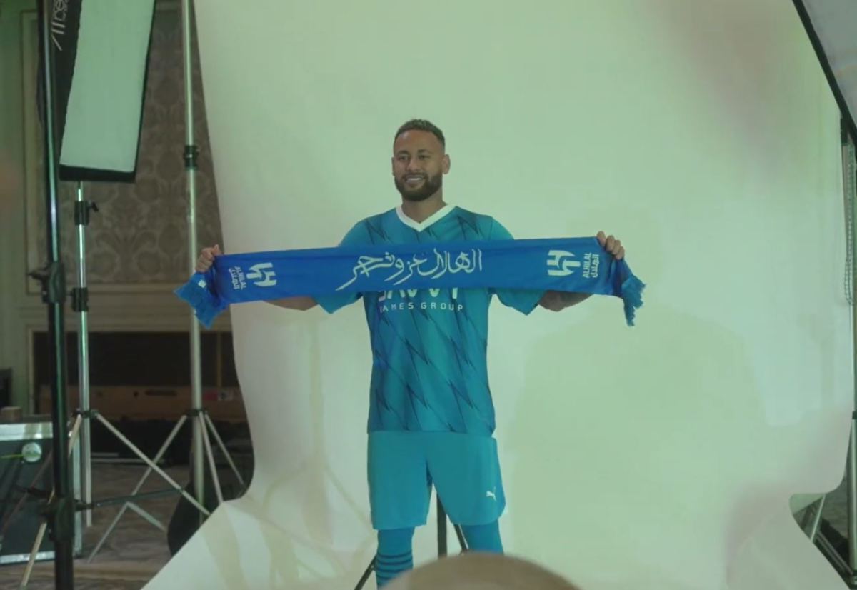 Neymar pictured wearing Al-Hilal kit and holding up a scarf after completing his transfer to the Saudi Pro League club from PSG in August 2023