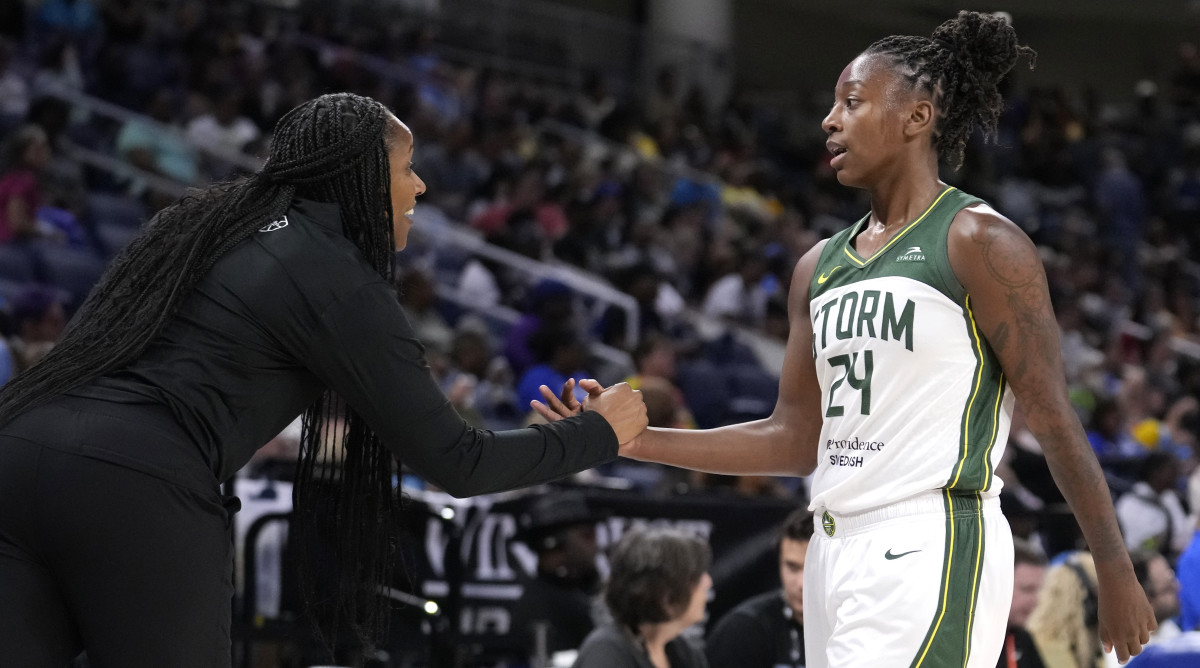 Seattle Storm coach Noelle Quinn welcomes Jewell Loyd back to the bench during the second half of the team's WNBA basketball game against the Chicago Sky.