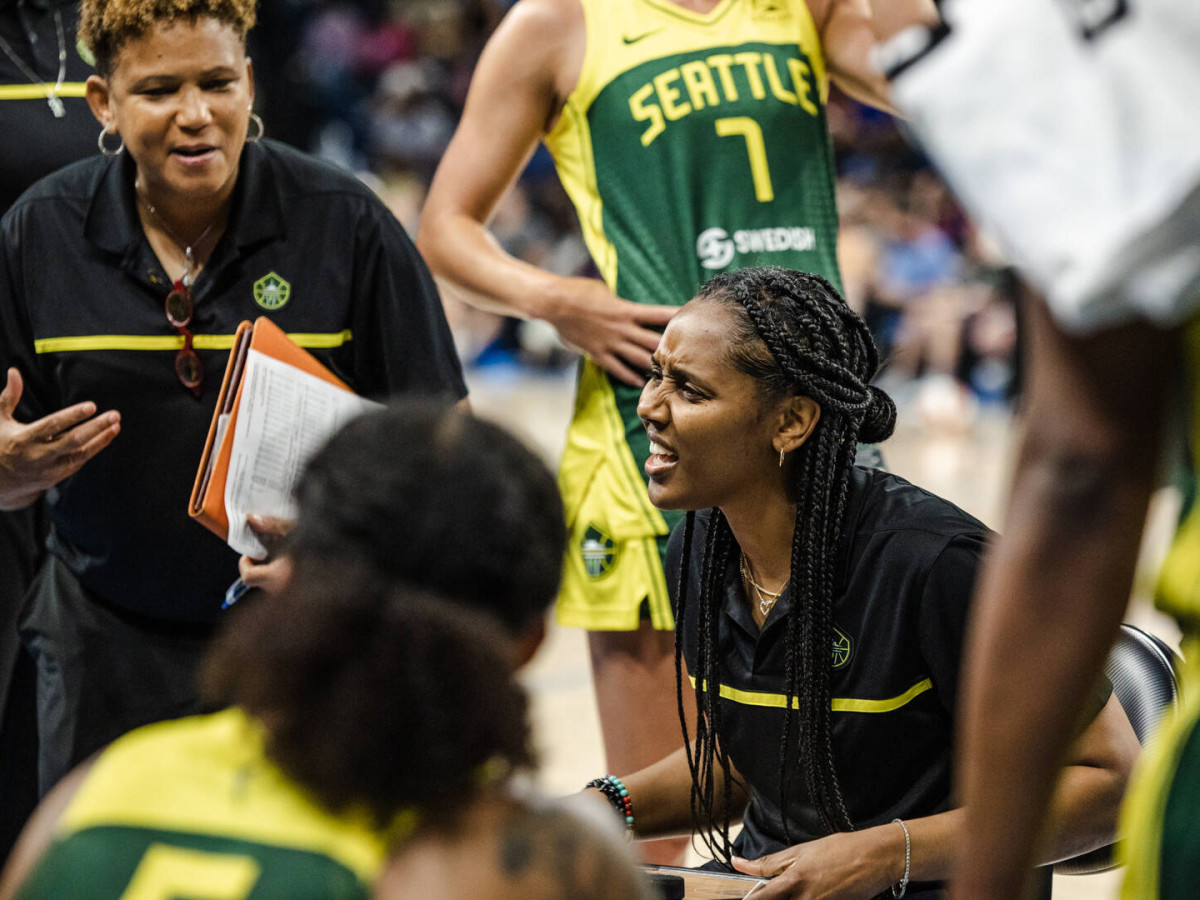 Seattle Storm coach Noelle Quinn coaches her players in a huddle on the bench during a game against the Sky.