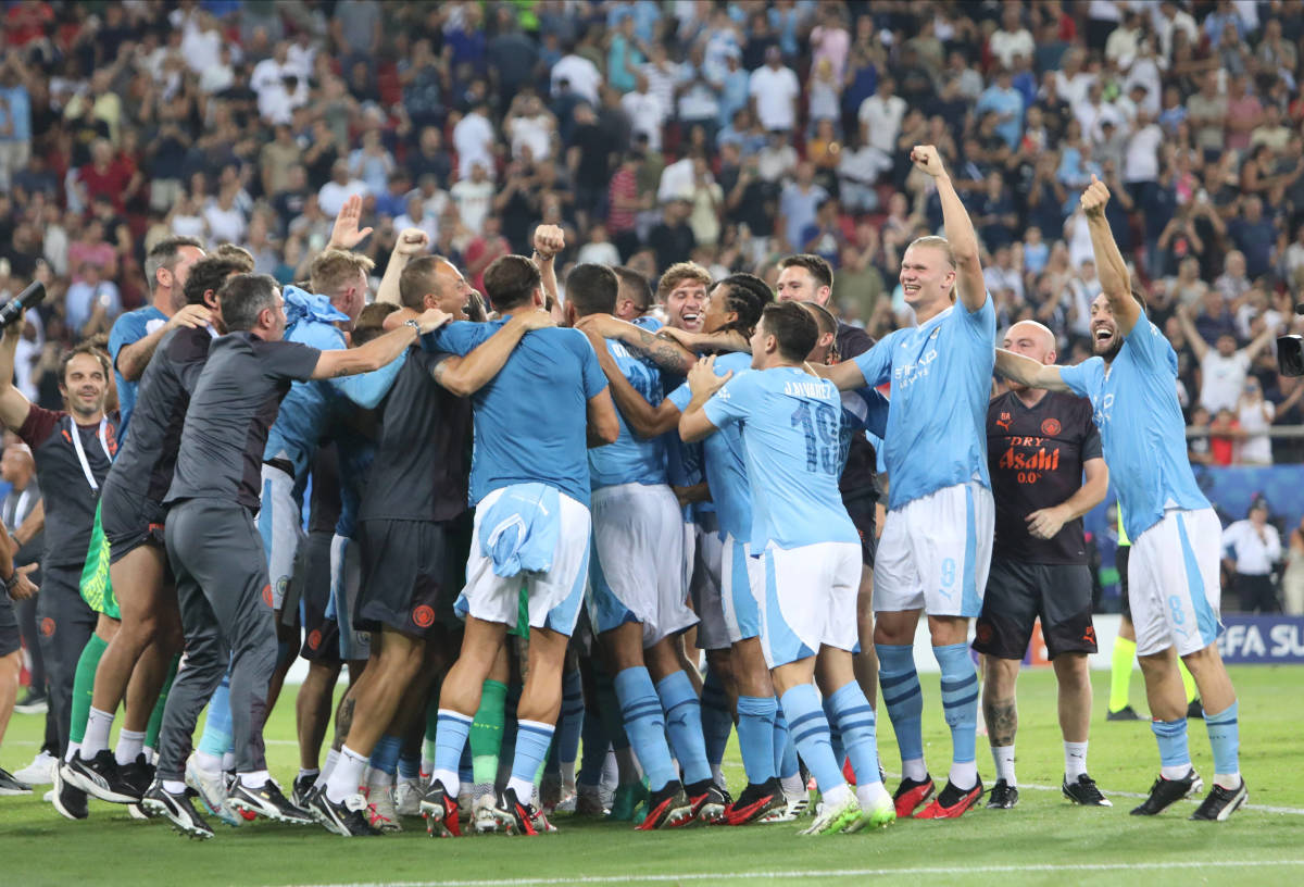 Manchester City's players and coaching staff pictured celebrating after beating Sevilla on penalties in the 2023 UEFA Super Cup final