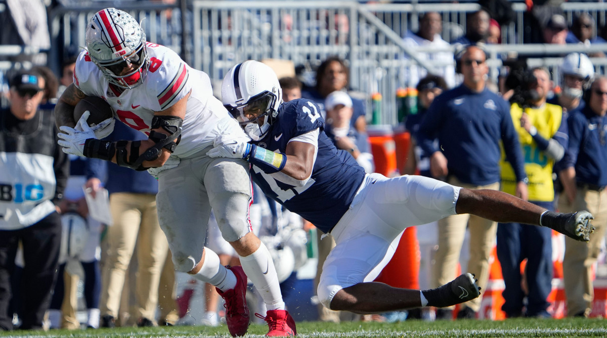 Ohio State Buckeyes tight end Cade Stover drags Penn State Nittany Lions linebacker Abdul Carter.