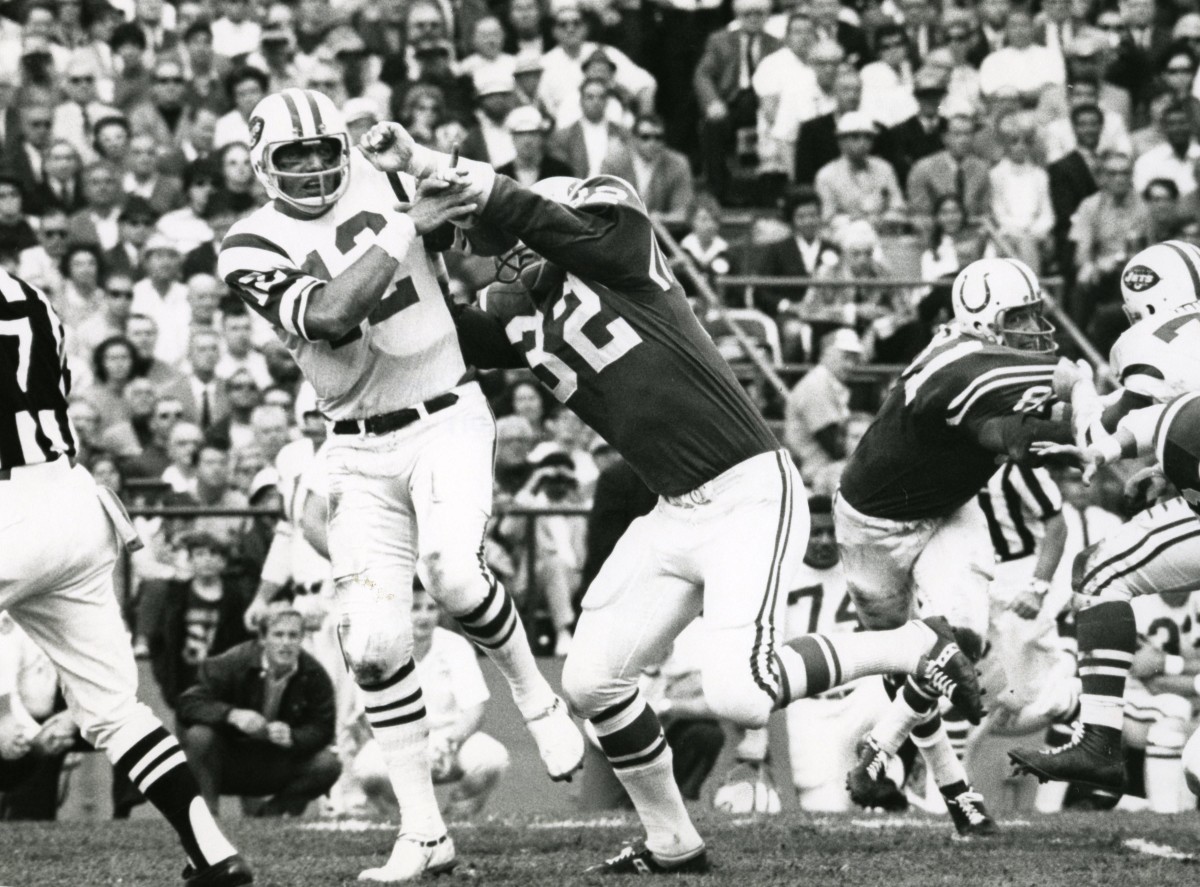 New York Jets quarterback Joe Namath (12) is hit after throwing the ball by Baltimore Colts linebacker Mike Curtis (32) during Super Bowl III at the Orange Bowl. The Jets defeated the Colts 16-7.