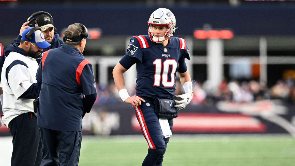 Jan 1, 2023; Foxborough, Massachusetts, USA; New England Patriots quarterback Mac Jones (10) talks with head coach Bill Belichick and Matthew Patricia during the second half of a game at Gillette Stadium.