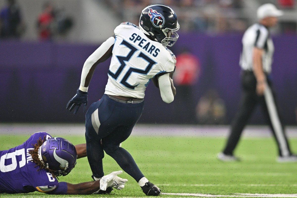 Tennessee Titans running back Tyjae Spears (32) runs the ball as Minnesota Vikings safety Lewis Cine (6) looks to make the tackle during the first quarter at U.S. Bank Stadium.