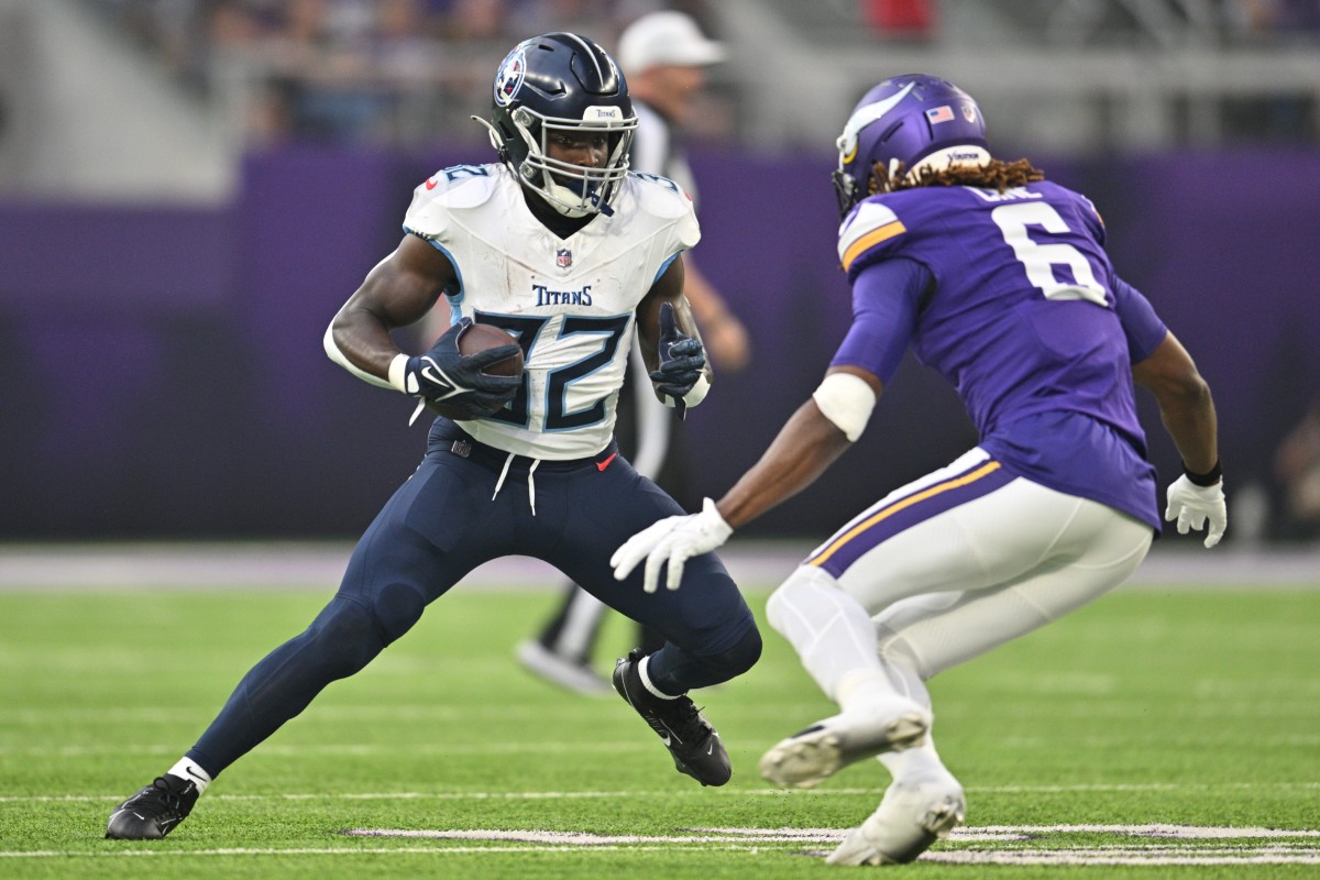Tennessee Titans running back Tyjae Spears (32) runs the ball as Minnesota Vikings safety Lewis Cine (6) looks to make the tackle during the first quarter at U.S. Bank Stadium.
