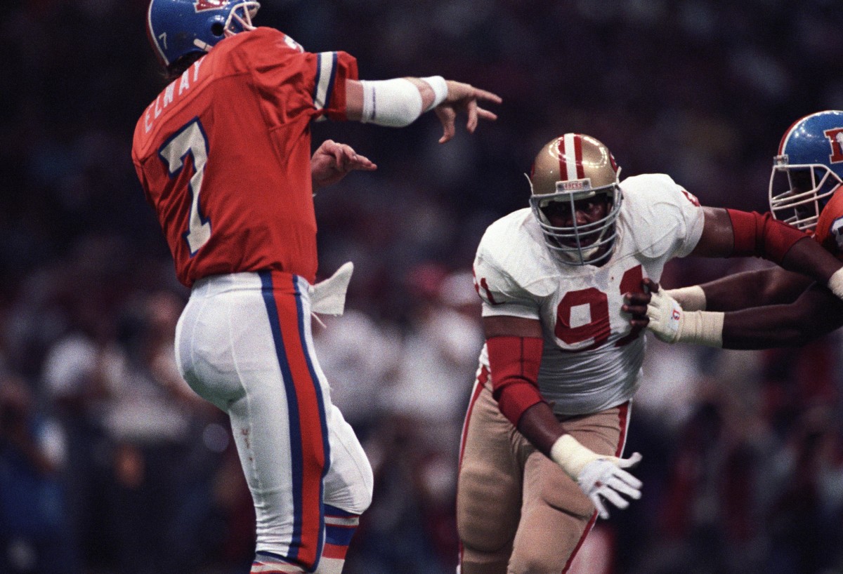 Denver Broncos quarterback John Elway (7) in action against San Francisco 49ers defensive end Larry Roberts (91) during Super Bowl XXIV at the Superdome. The 49ers defeated the Broncos 55-10.