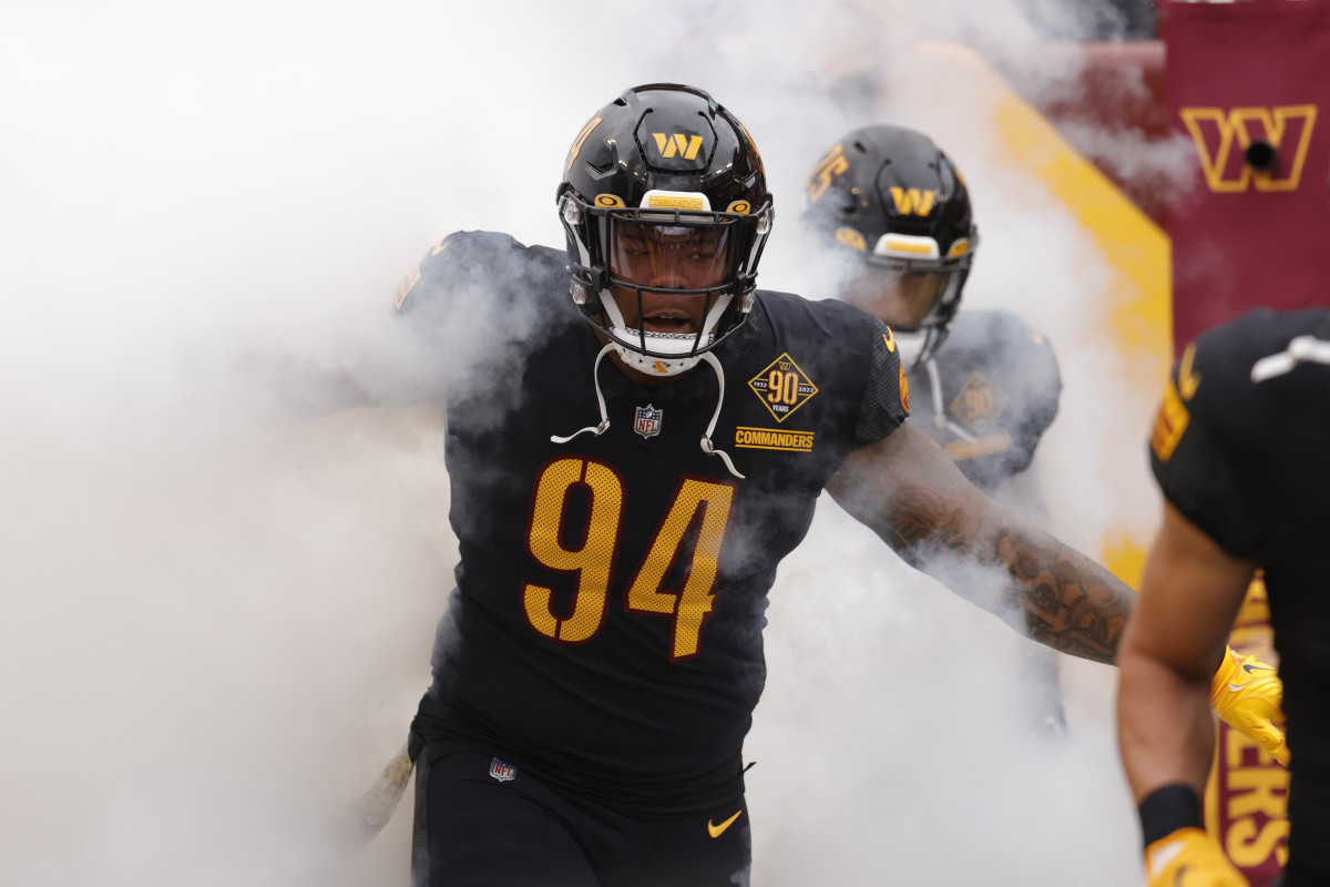 Washington Commanders defensive tackle Daron Payne (94) runs out of the tunnel with smoke billowing around him