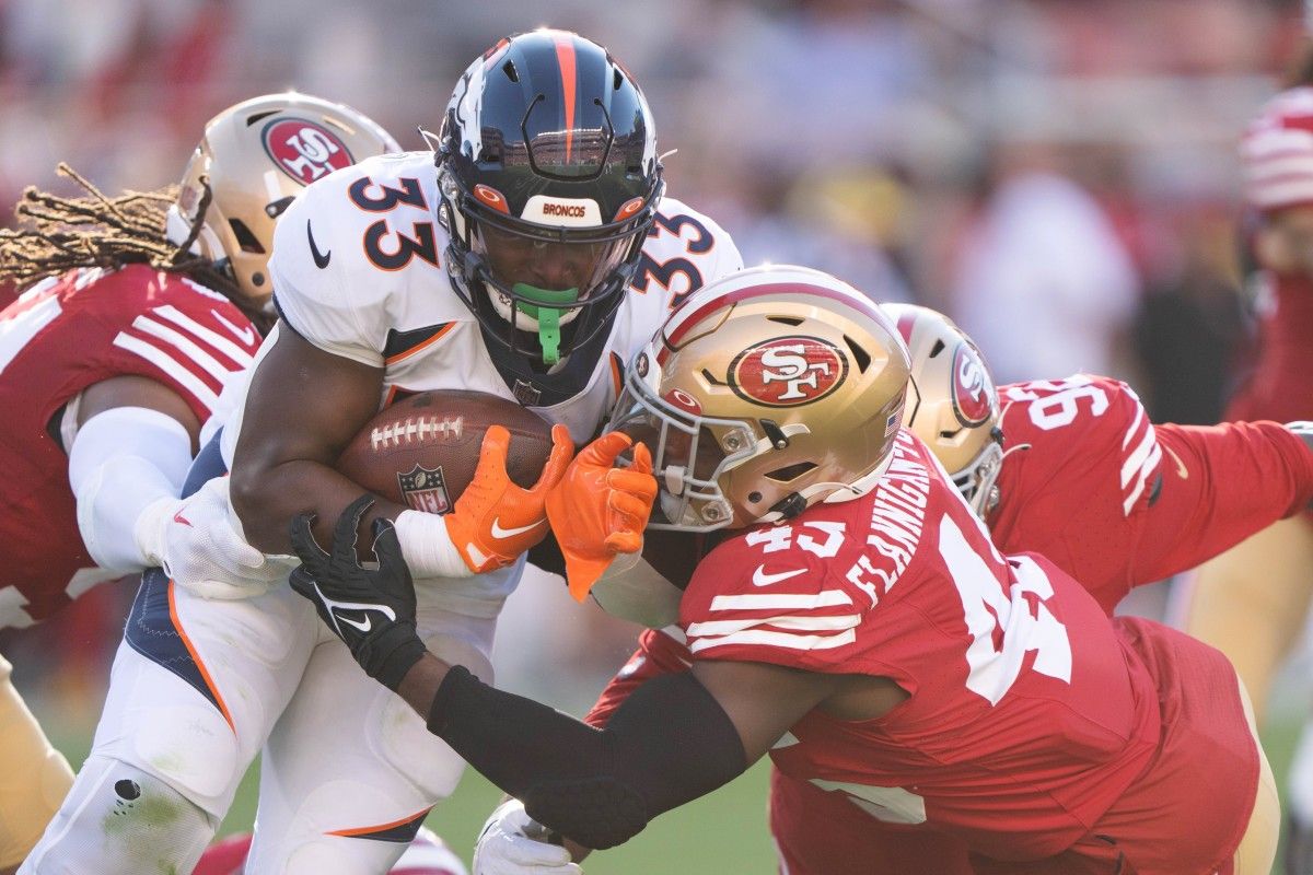 Denver Broncos running back Javonte Williams (33) gets tackled by San Francisco 49ers linebacker Demetrius Flannigan-Fowles (45) during the first quarter at Levi's Stadium.