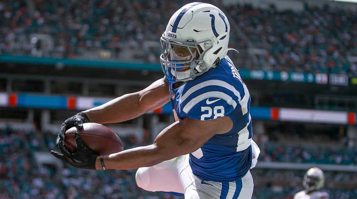 Colts running back Jonathan Taylor holds out the ball for a touchdown