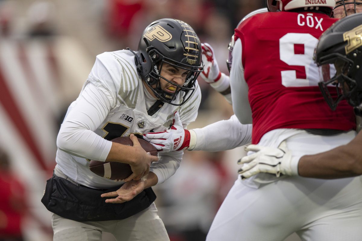 Aidan O’Connell runs with the ball tucked under one hand as Indiana defenders try to reach it