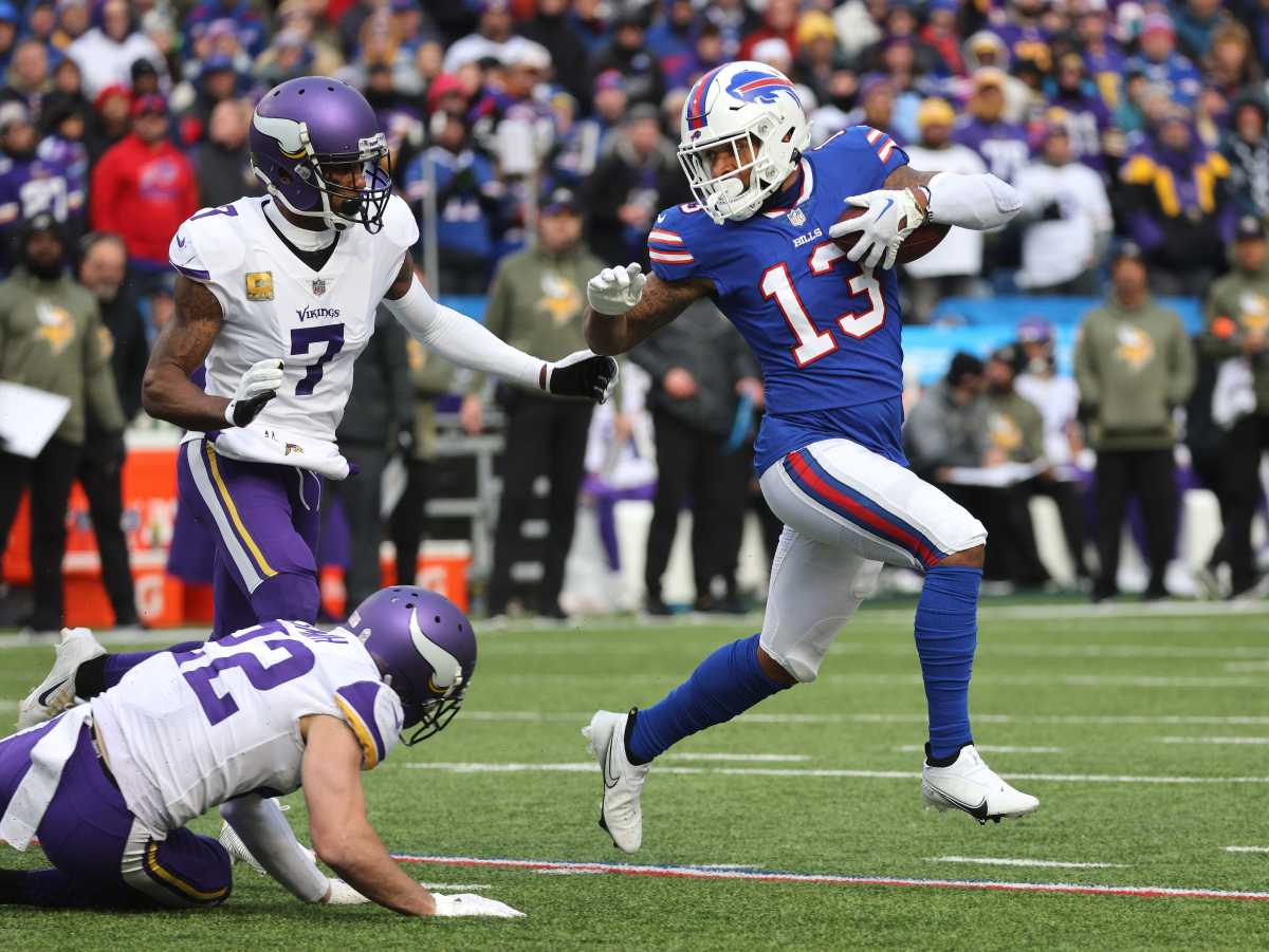 Gabe Davis turns and runs with the ball in one hand as two Vikings players try to reach him