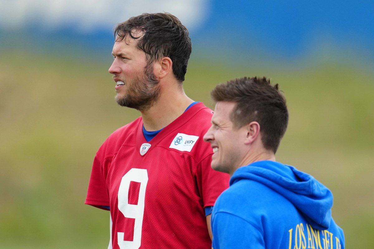 Matthew Stafford and Mike LaFleur stand next to each other, both squinting a bit at the field ahead of them