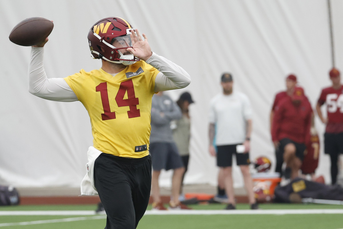 Sam Howell brings his arm back to throw the football at camp