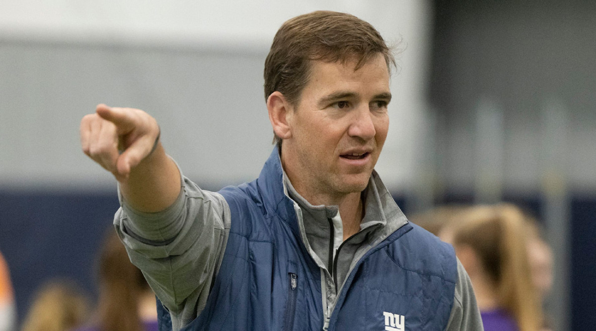 Former Giants quarterback Eli Manning helps with a team girls football clinic.