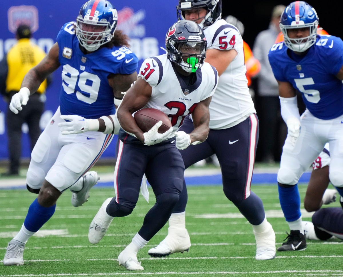 Dameon Pierce runs with the ball as Giants players chase after him