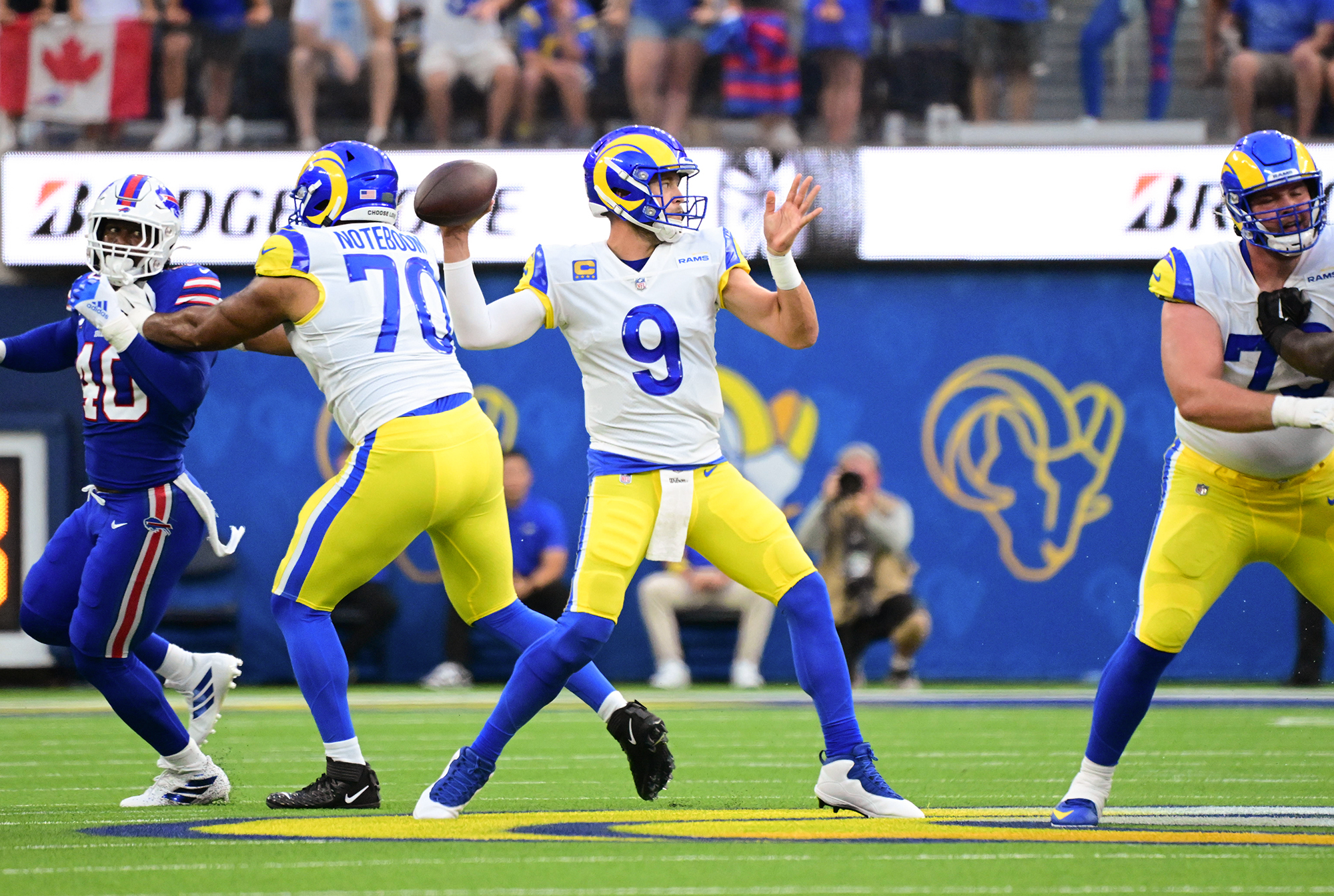 Matthew Stafford brings his arm back to throw the ball as a Rams O-lineman blocks a Bills defender behind him