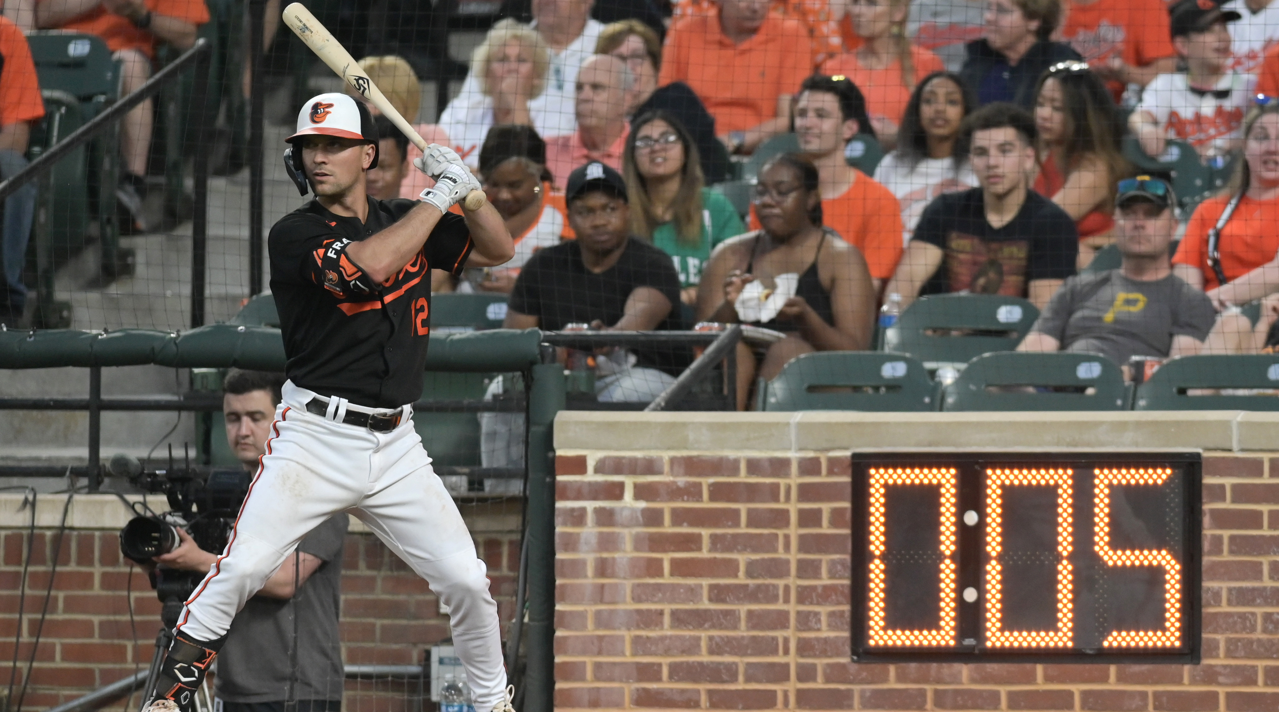 Baltimore Orioles second baseman Adam Frazier warms up next to the pitch clock during at Oriole Park at Camden Yards.