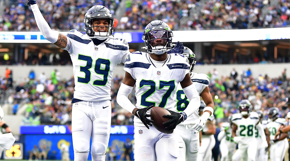 Seahawks cornerback Tariq Woolen, right, celebrates intercepting a pass with teammate Teez Tabor