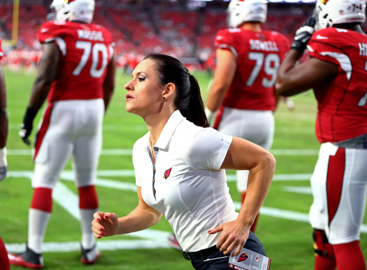 Jen Welter runs on the sidelines as a coach for the Arizona Cardinals.