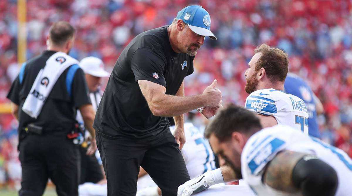 Dan Campbell fist bumps a player before a Week 1 game against the Chiefs